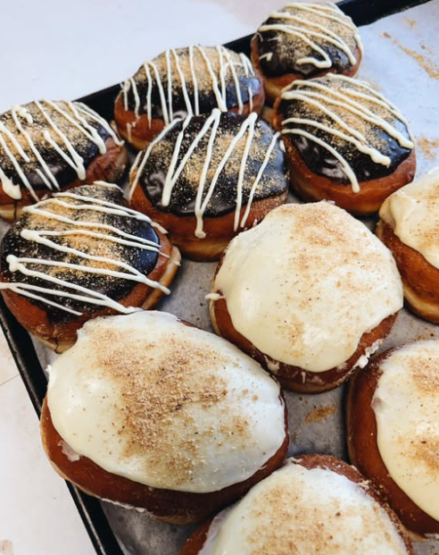 Filled doughnuts topped with cream cheese frosting and cinnamon