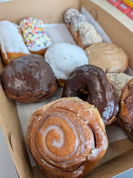 A box of assorted fresh doughnuts and a cinnamon roll